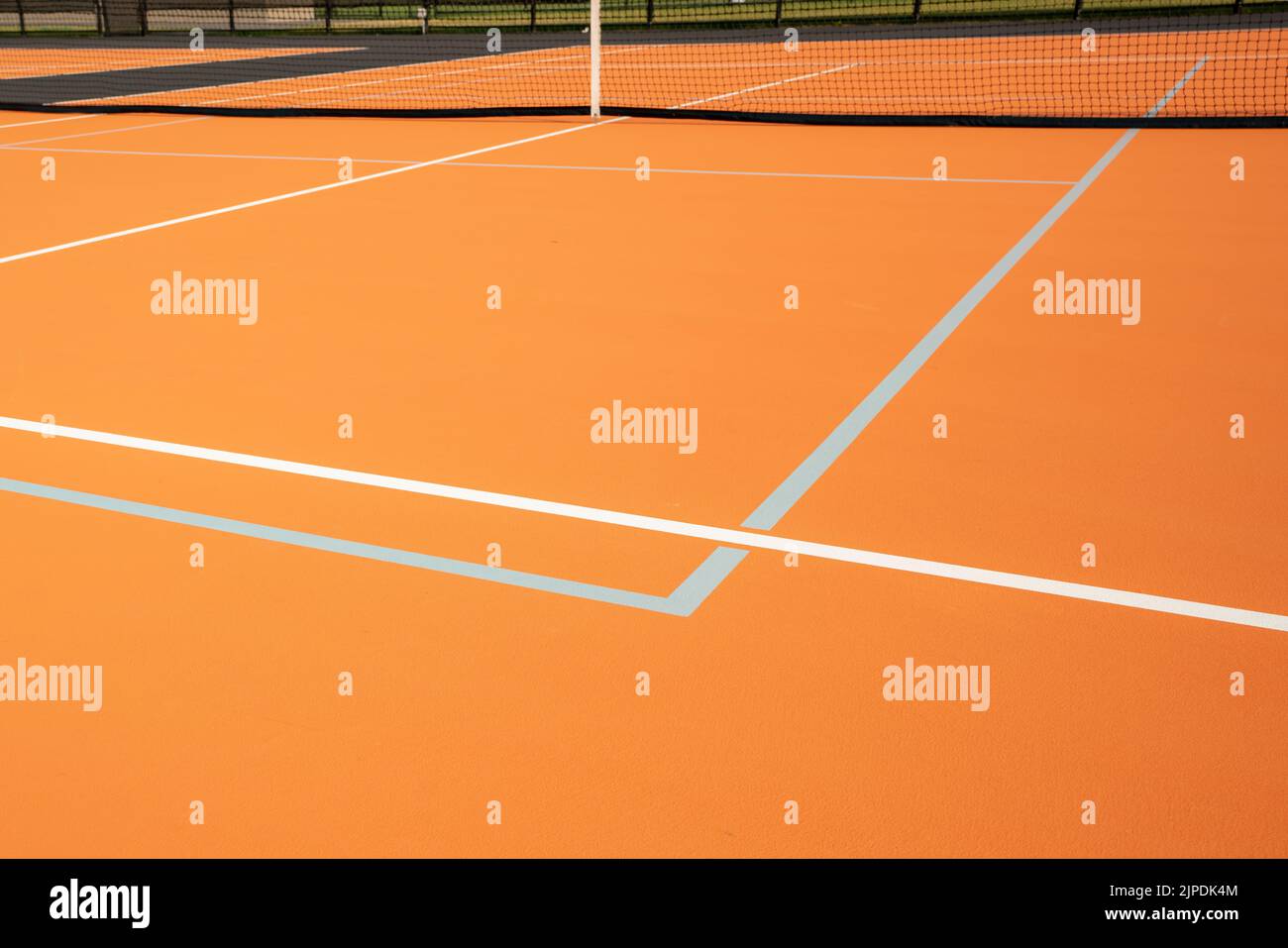 Insolito campo da tennis arancione all'aperto con linee bianche e linee combinate di pickleball grigio chiaro. Foto Stock