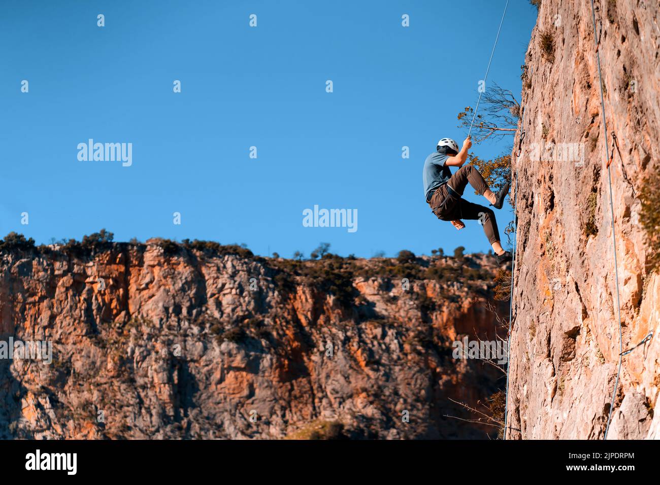 L'uomo sta arrampicandosi sulle rocce nei montani. Foto Stock