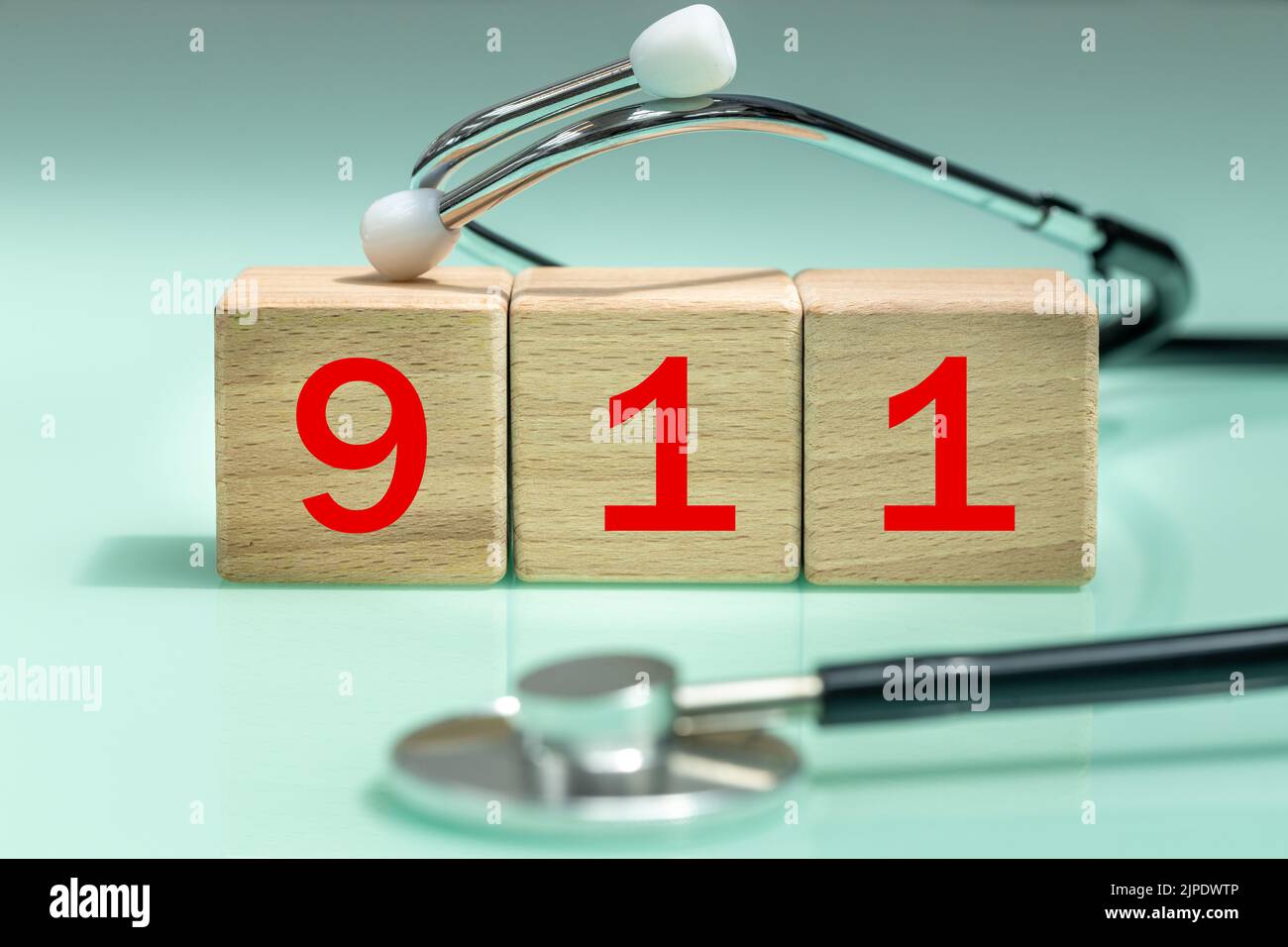 Numero di emergenza 911, numeri rossi su blocchi di legno, stetoscopio medico, concetto di numero di contatto internazionale Foto Stock