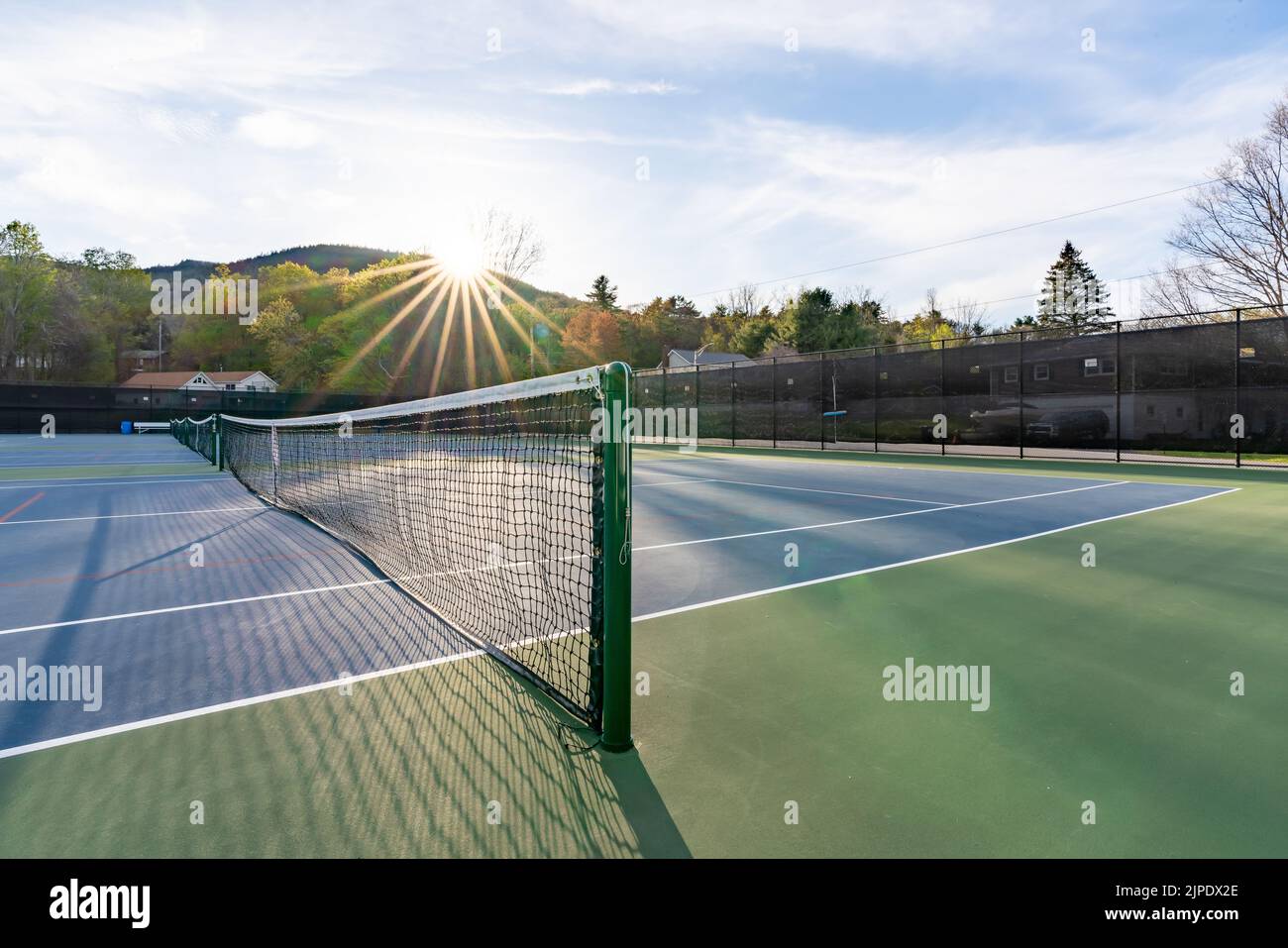 Nuovi campi da tennis blu all'aperto con linee bianche e linee rosse di pickleball e stella del sole sullo sfondo. Foto Stock