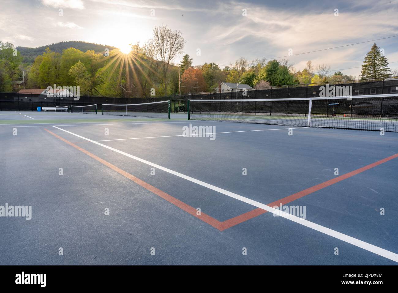 Nuovi campi da tennis blu all'aperto con linee bianche e linee rosse di pickleball e stella del sole sullo sfondo. Foto Stock