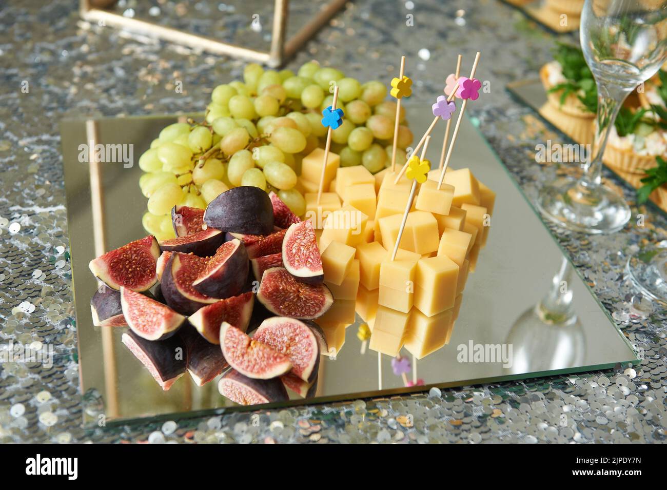 Frutta e formaggio su un piatto a specchio per uno spuntino Foto Stock