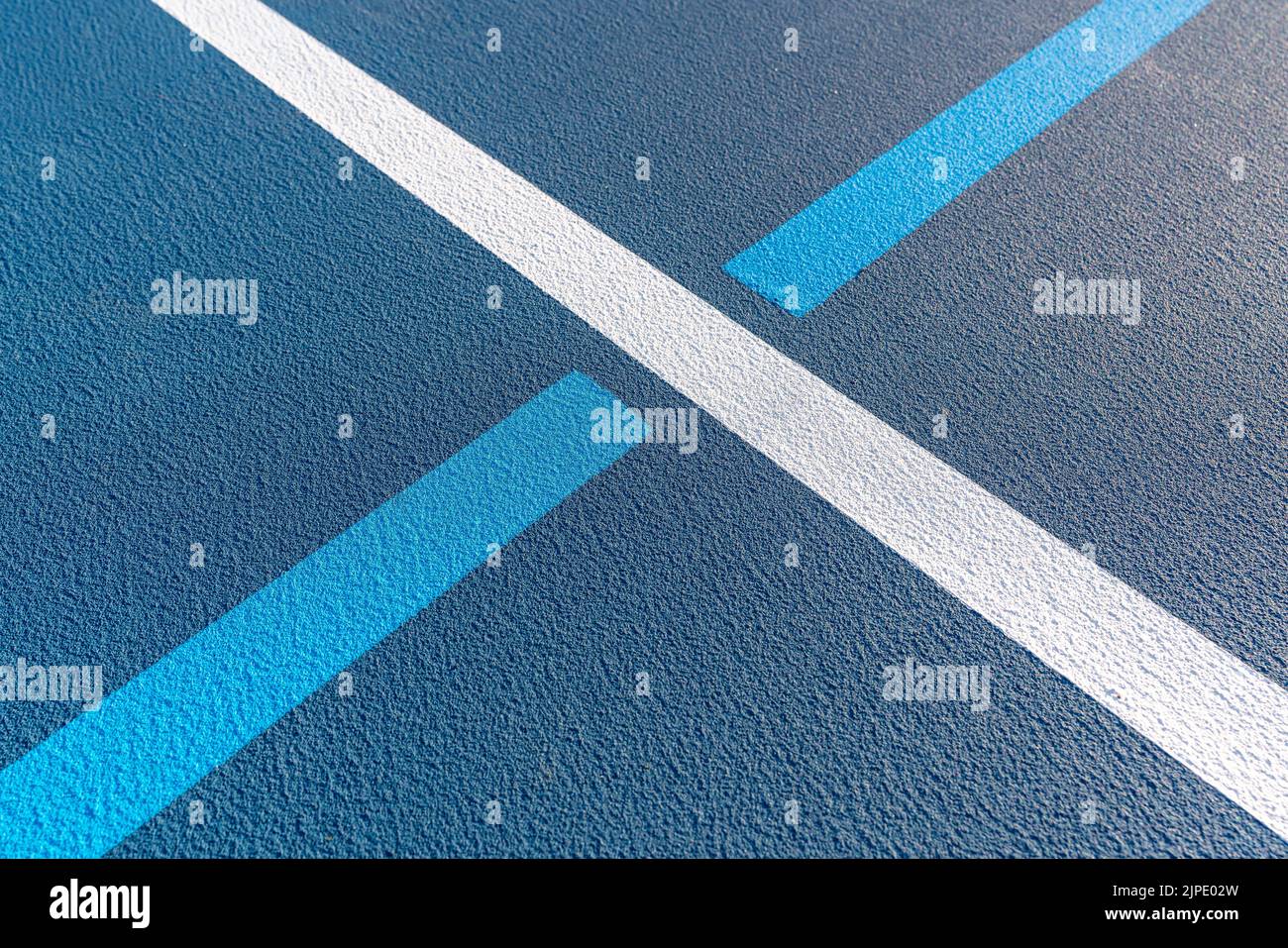 Foto ravvicinata del nuovo campo da tennis blu all'aperto con linee di pickleball blu chiaro. Foto Stock