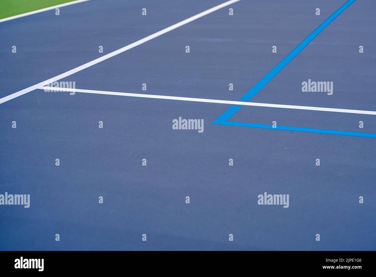 Foto ravvicinata del nuovo campo da tennis blu all'aperto con linee di pickleball blu chiaro. Foto Stock