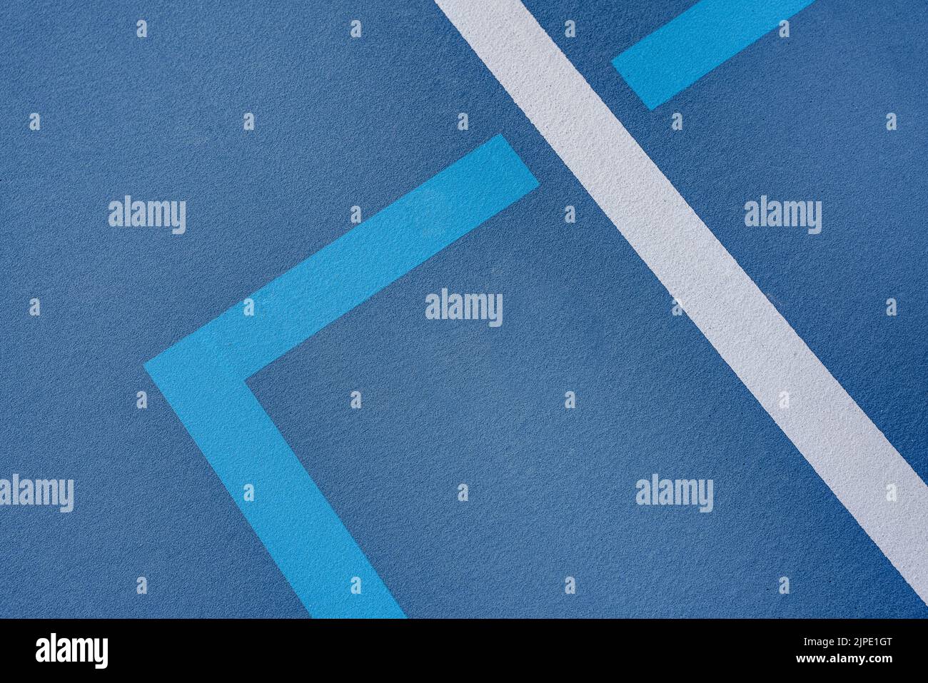 Foto ravvicinata del nuovo campo da tennis blu all'aperto con linee di pickleball blu chiaro. Foto Stock