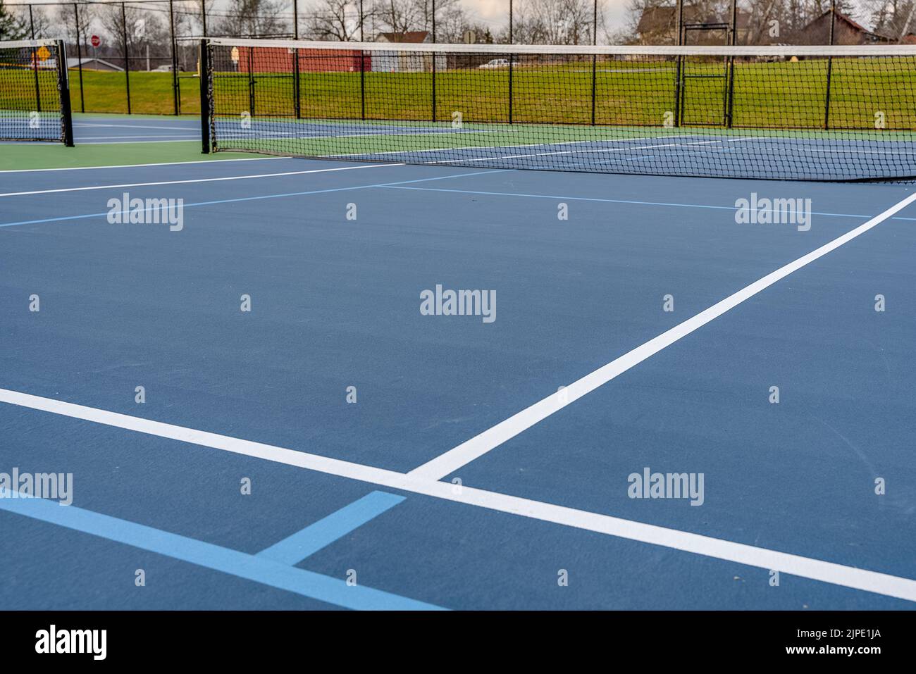 Foto ravvicinata del nuovo campo da tennis blu all'aperto con linee di pickleball blu chiaro. Foto Stock