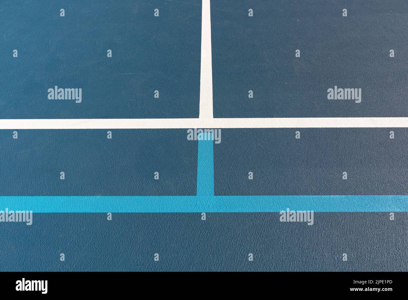 Foto ravvicinata del nuovo campo da tennis blu all'aperto con linee di pickleball blu chiaro. Foto Stock