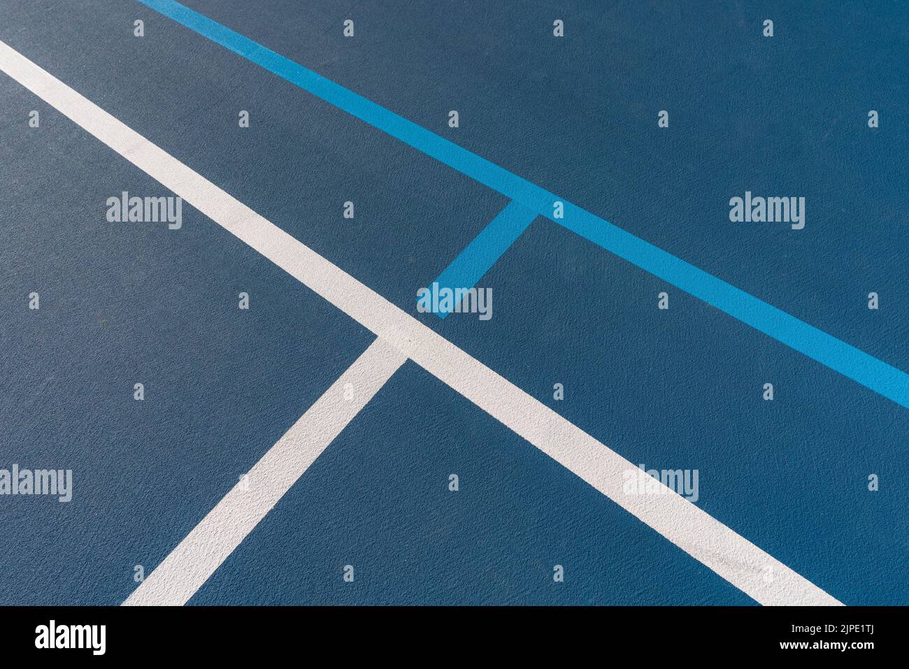 Foto ravvicinata del nuovo campo da tennis blu all'aperto con linee di pickleball blu chiaro. Foto Stock