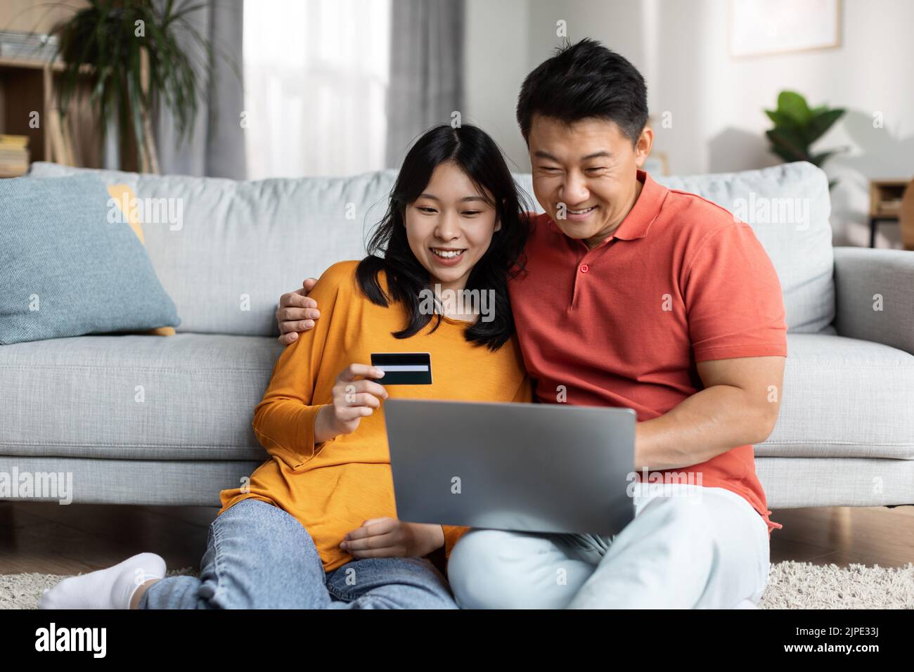 Sposi giapponesi rilassati usando il notebook e la carta di credito Foto Stock