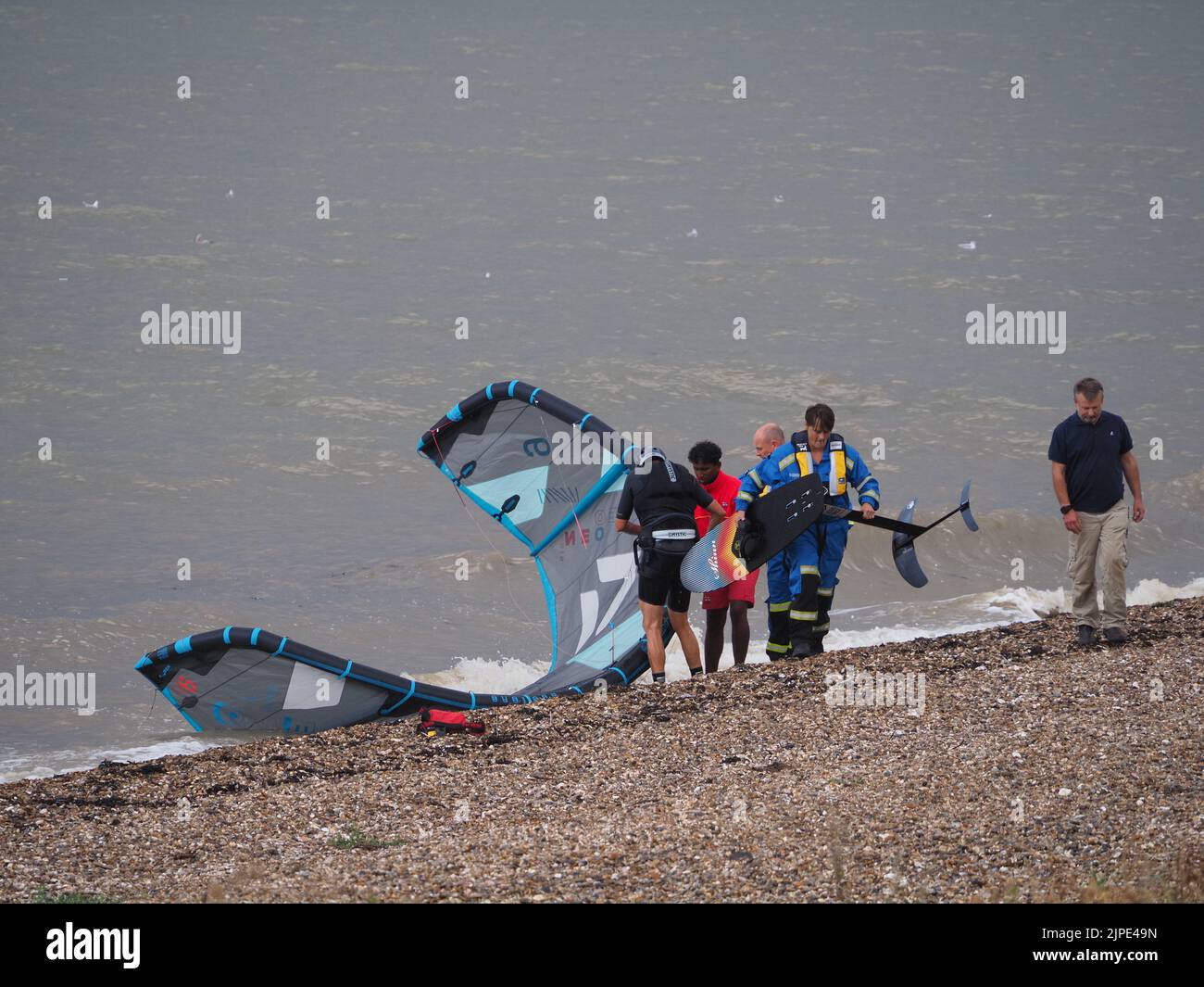 Minster on Sea, Kent, Regno Unito. 17th ago, 2022. UK Weather: Un kite surfer sembrava essere in difficoltà proprio come le nuvole di tempesta hanno rotolato su Minster sul lungomare di mare questo pomeriggio. Il kite surfer è stato incontrato dalla guardia costiera e da un bagnino. Il kite surfer swam la loro tavola e kite di nuovo a riva dopo aver sperimentato le difficoltà. La scialuppa di salvataggio costiera fu lanciata, ma il kite surfer riuscì a riportarla a riva da solo. Credit: James Bell/Alamy Live News Foto Stock
