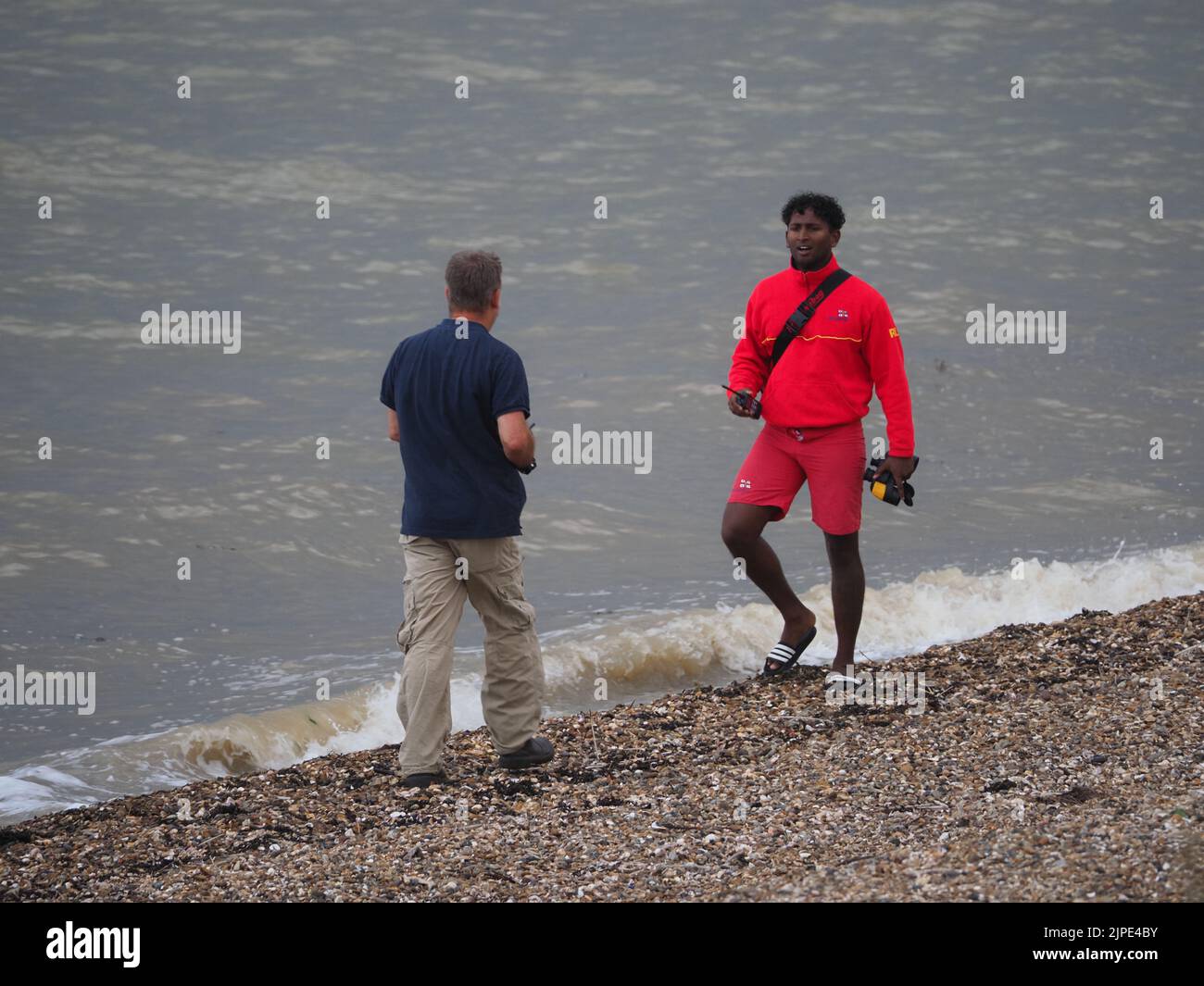 Minster on Sea, Kent, Regno Unito. 17th ago, 2022. UK Weather: Un kite surfer sembrava essere in difficoltà proprio come le nuvole di tempesta hanno rotolato su Minster sul lungomare di mare questo pomeriggio. Il kite surfer è stato incontrato dalla guardia costiera e da un bagnino. Il kite surfer swam la loro tavola e kite di nuovo a riva dopo aver sperimentato le difficoltà. La scialuppa di salvataggio costiera fu lanciata, ma il kite surfer riuscì a riportarla a riva da solo. Credit: James Bell/Alamy Live News Foto Stock