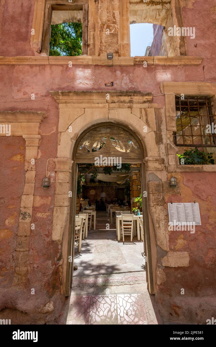 bell'edificio in stile derelitto battuto dal tempo vecchio con porta ad arco come ingresso nella città greca di rethymno sull'isola di creta in grecia. Foto Stock