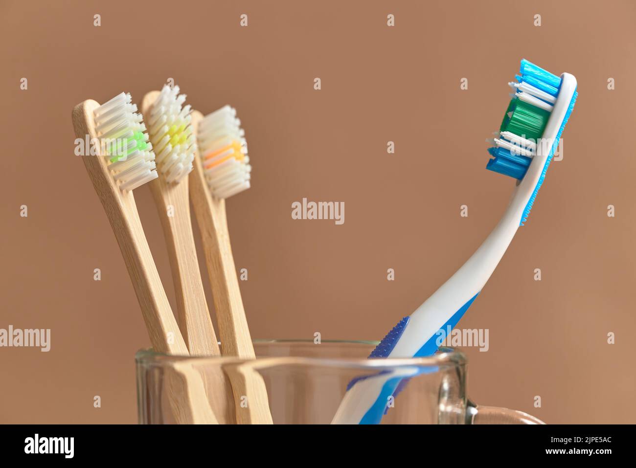 Spazzolini da denti, uno di plastica e un set di tre ecologici di bambù. Concetti: Stile di vita sostenibile, scelta di biodegradabile compostabile e env Foto Stock