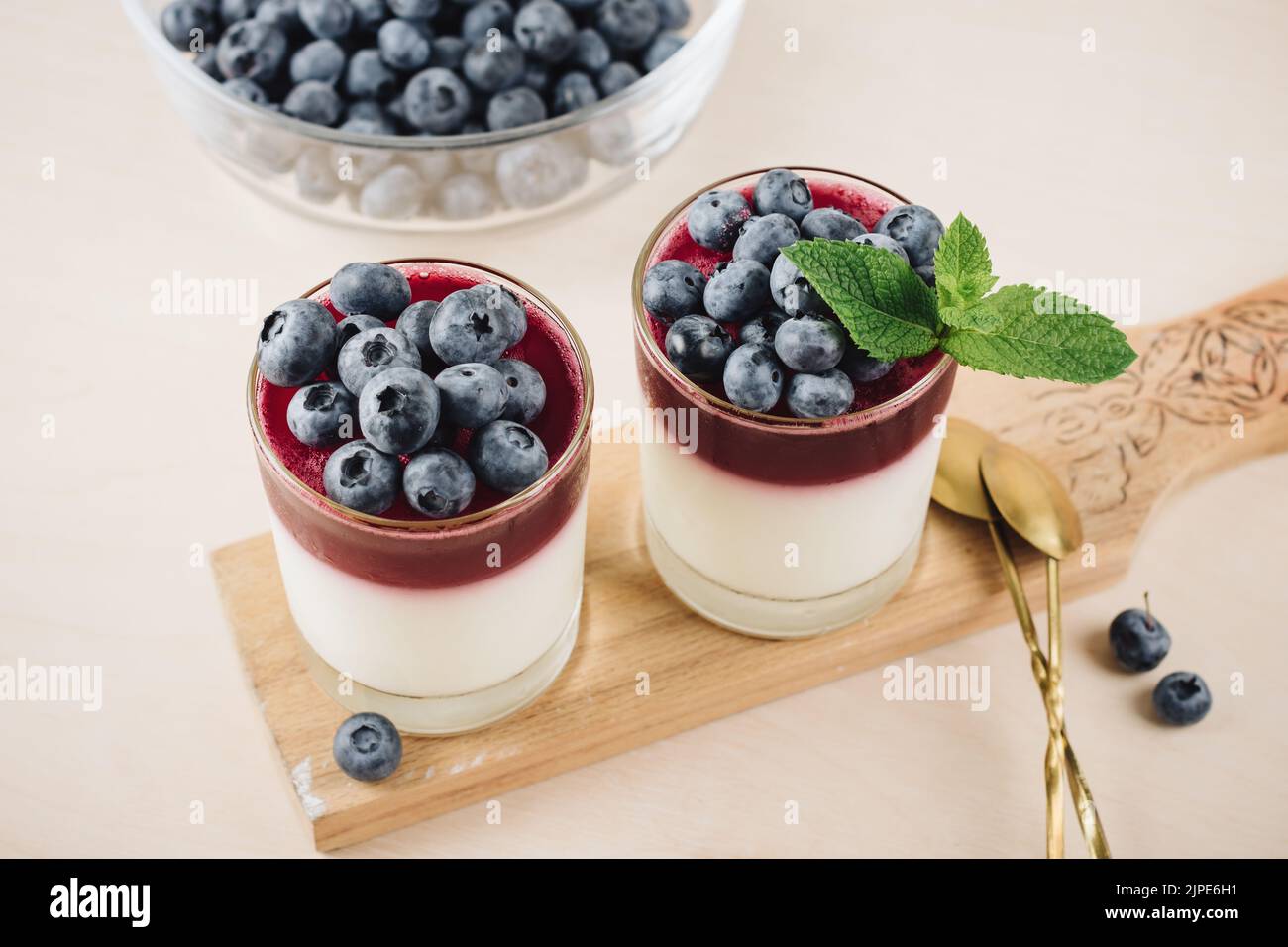 Due bicchieri di gelatina dessert con mirtilli. Yogurt e gelatina di mirtillo. Foto Stock