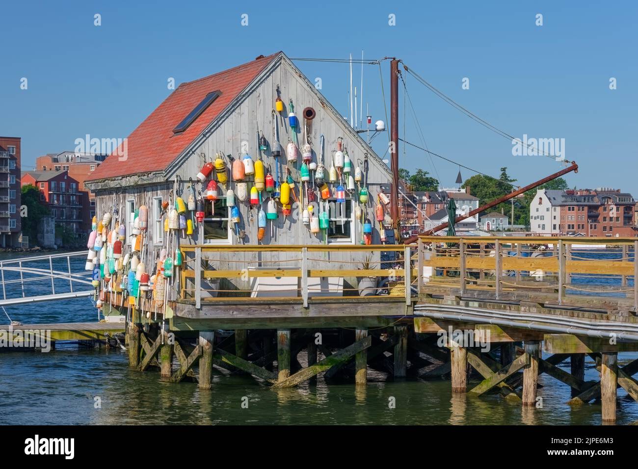 Una vecchia aragosta dal tetto rosso decotata con molti galleggianti e altre paraphernalia di pesca. Foto Stock
