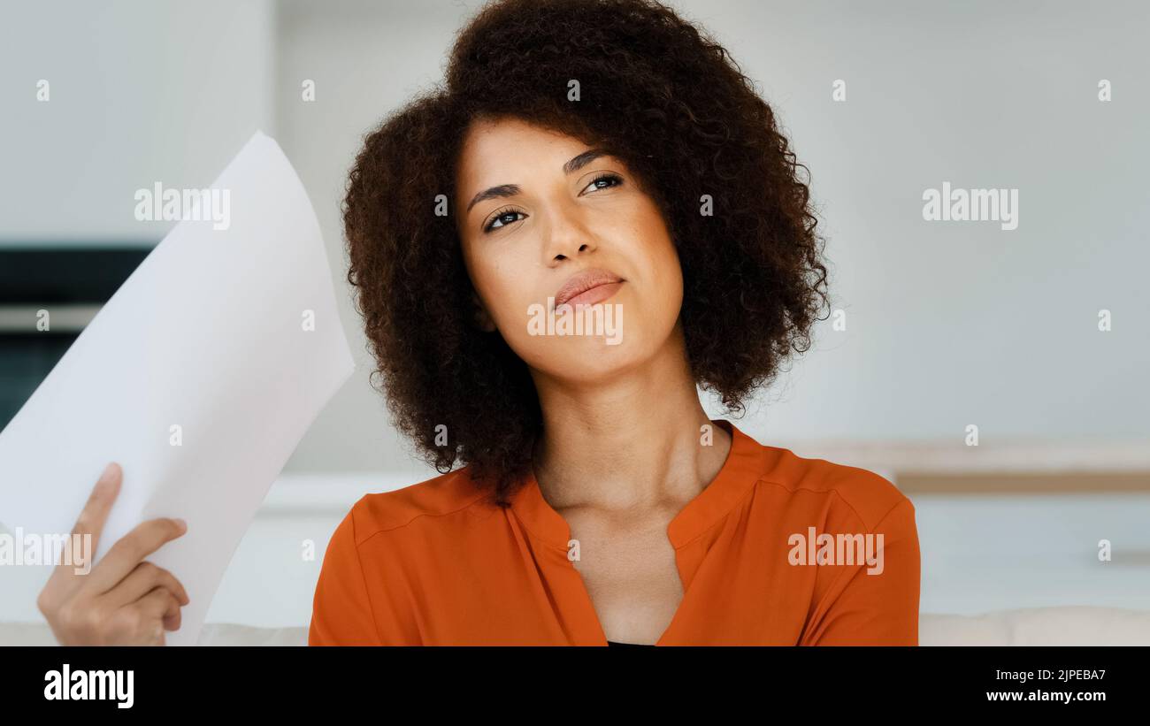 Ritratto Afro americano donna pensiva con capelli ricci si sente alto grado calore estate tempo ripieno ondulazione documenti documenti che fanno vento pensa pianificazione Foto Stock