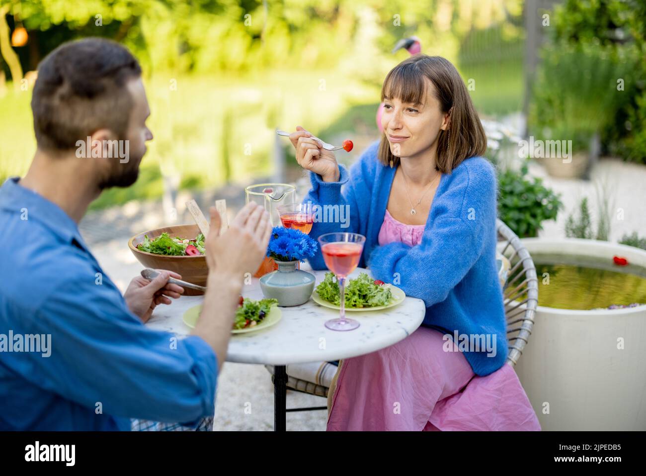 Giovane uomo e donna che mangiano cibo sano, trascorrendo l'estate insieme all'aperto Foto Stock