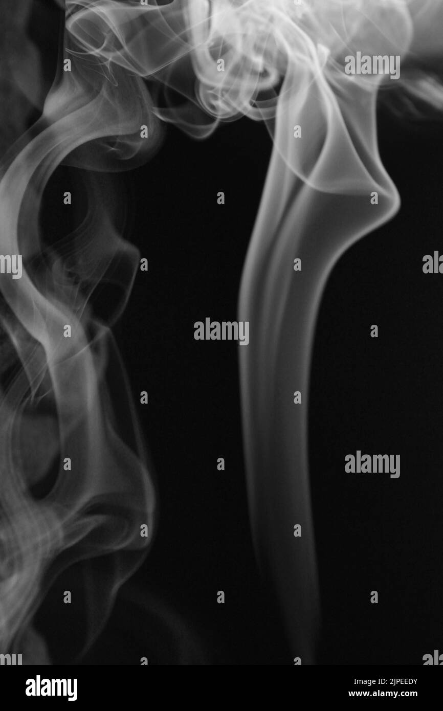 Un colpo di fumo verticale isolato su uno sfondo nero Foto Stock