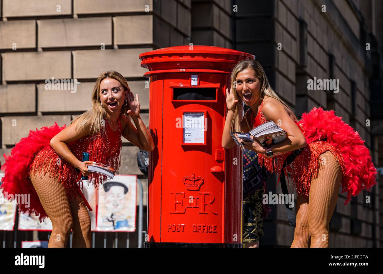 Edimburgo, Scozia, Regno Unito, 17th agosto 2022. Edinburgh Festival Fringe: Una casella postale parlante - una telecamera vintage candida prop per promuovere lo spettacolo di Mark Borkowski - i visitatori del Fringe 2022 sono sconvolti da una casella postale parlante. Le folle sul Royal Mile reagiscono al teatro di strada, mentre grida mentre le persone passano davanti. Nella foto: Blazin Hot Summer Dancers.Credit Sally Anderson/Alamy Live News Foto Stock