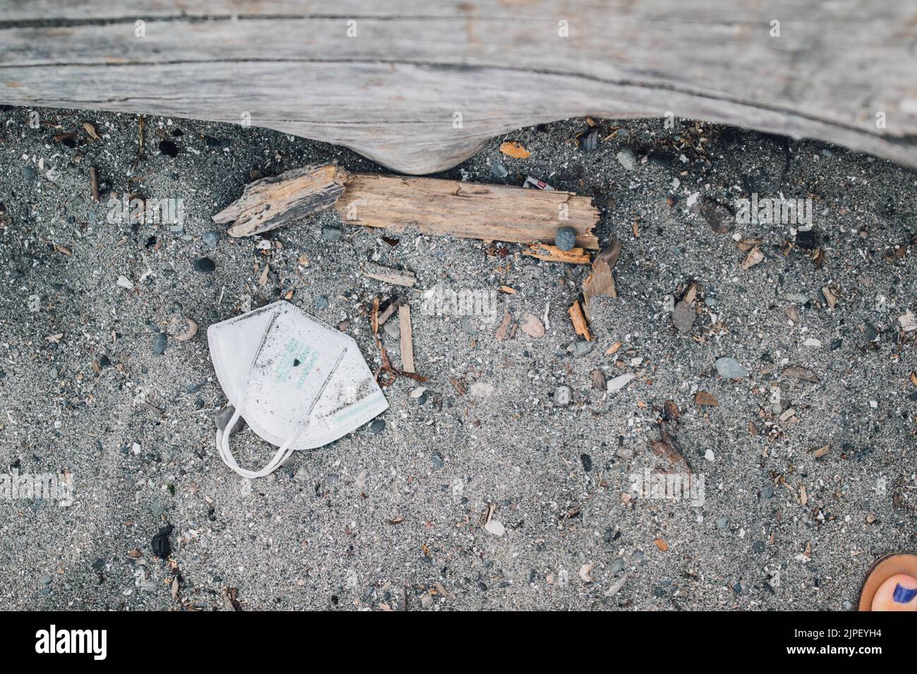 un abbandonato, usato kn95 maschera facciale su una spiaggia di sabbia, cucciolata Foto Stock