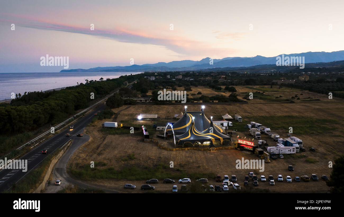 Grande cima di un circo con roulotte in un campo Foto Stock