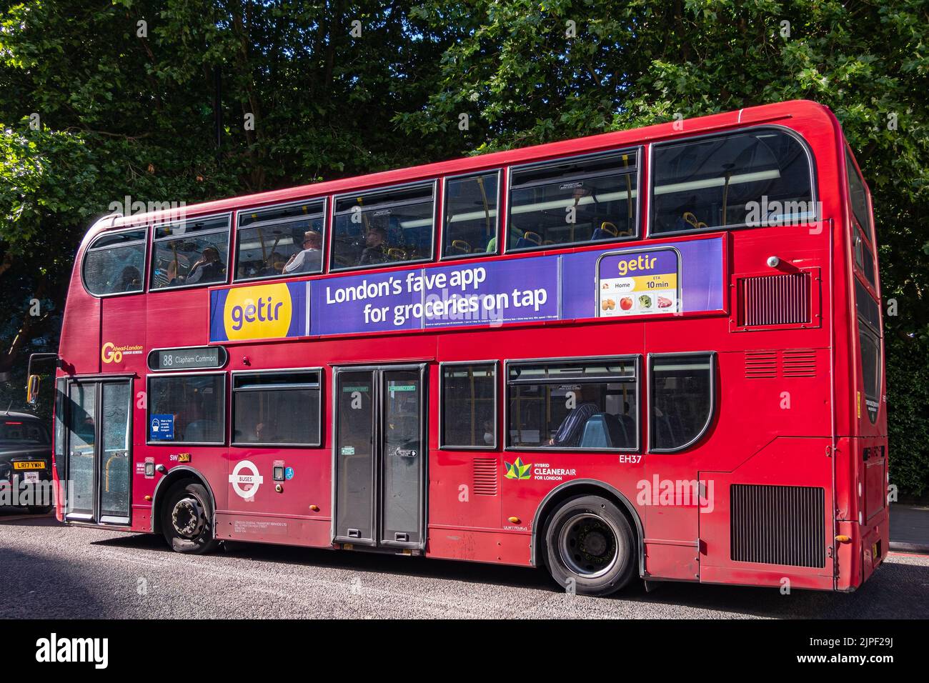 Londra, Regno Unito - 5 luglio 2022: Autobus pubblico a due piani rosso con annuncio sul lato per Getir su Albany Street, verde fogliame sul retro. Foto Stock