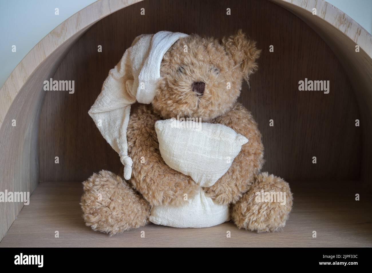 L'orso del sonno del giocattolo del peluche si siede su una mensola Foto Stock