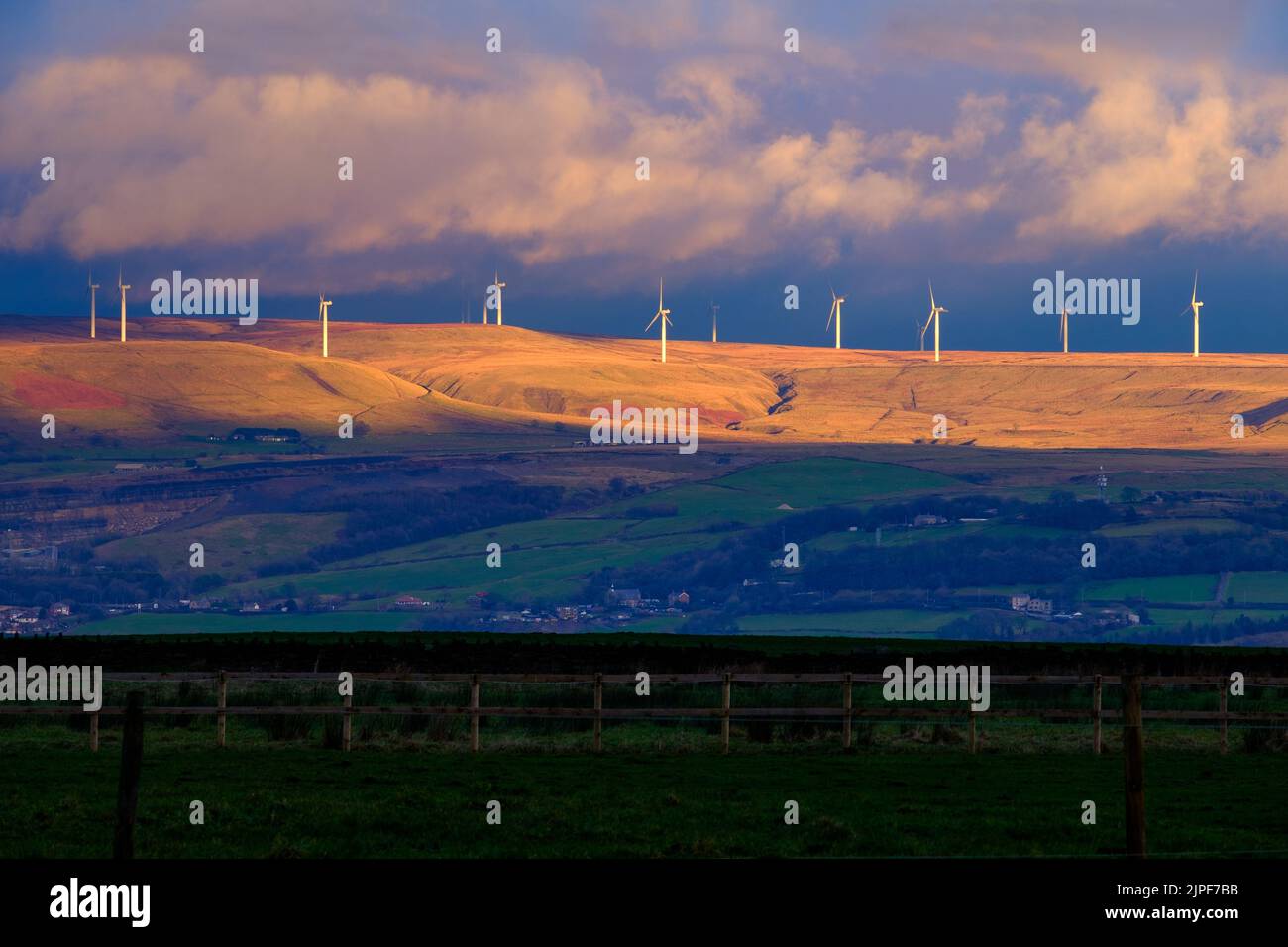 Turbine eoliche in condizioni di scarsa illuminazione sulla Scout Moor Skyline come visto da Affetside Village, Bolton UK Foto Stock