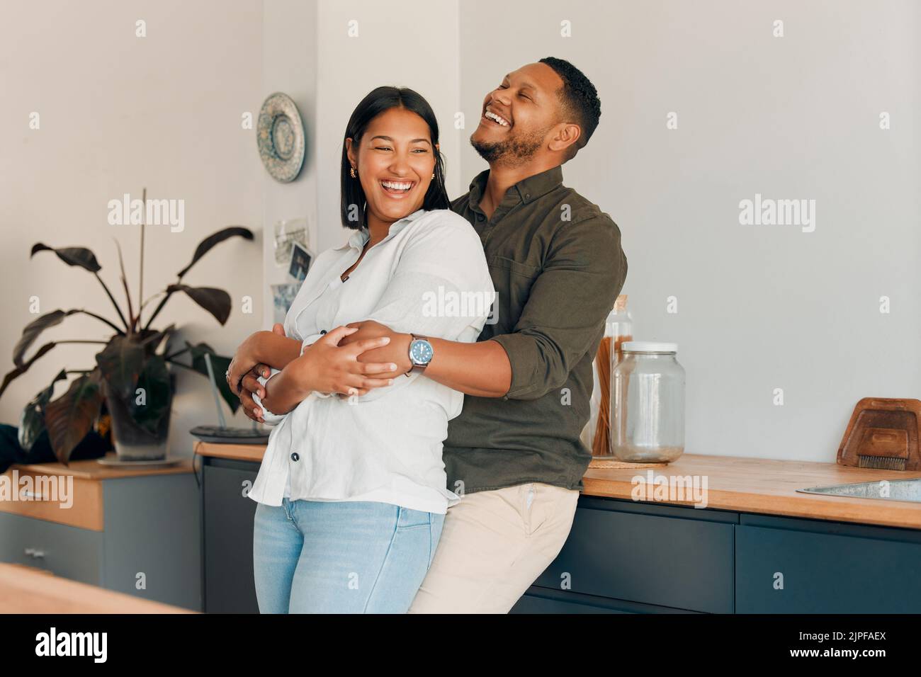 Abbracciando, abbracciando e innamorando la coppia in una casa soggiorno, cucina o salotto e legame, godendo di tempo insieme e rilassante. Sorridente, felice e. Foto Stock