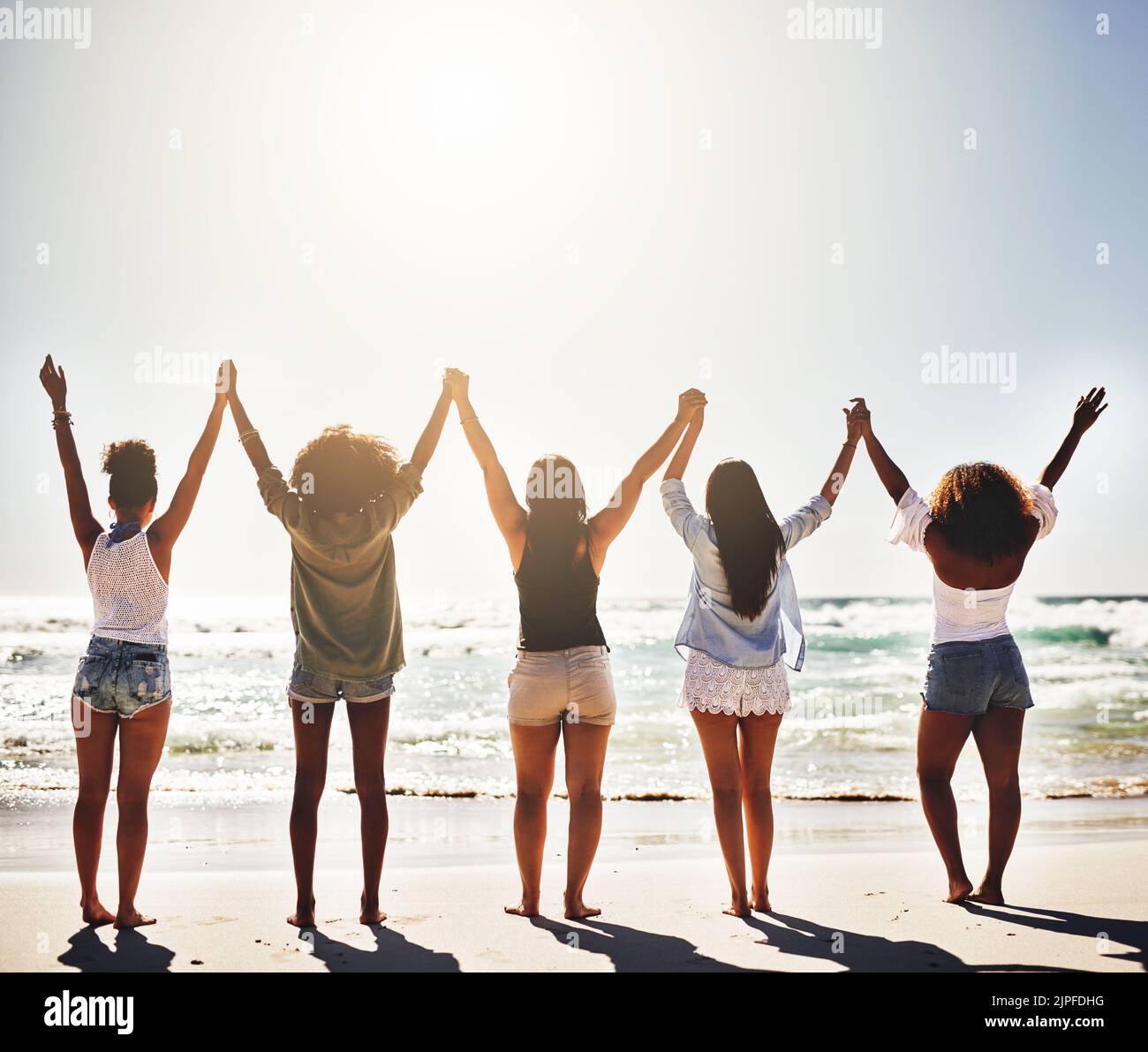 Perché i giorni di spiaggia è per che cosa viviamo. Vista posteriore di un gruppo di fidanzate che tengono le mani in solidarietà. Foto Stock