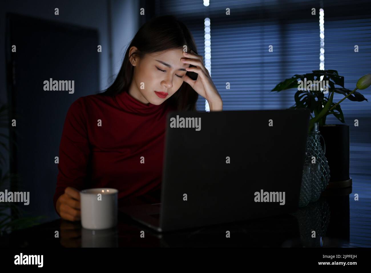Stressato giovane donna d'affari asiatica o lavoratrice d'ufficio che lavora a tarda notte in ufficio sovraccarico, duro lavoro donna, scadenza. Foto Stock