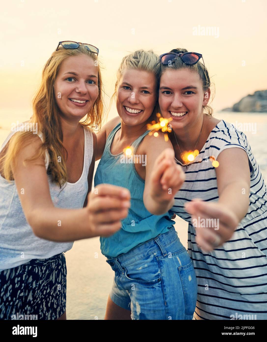 La nostra amicizia non perderà mai la sua scintilla. Giovani donne migliori amici appesi alla spiaggia. Foto Stock