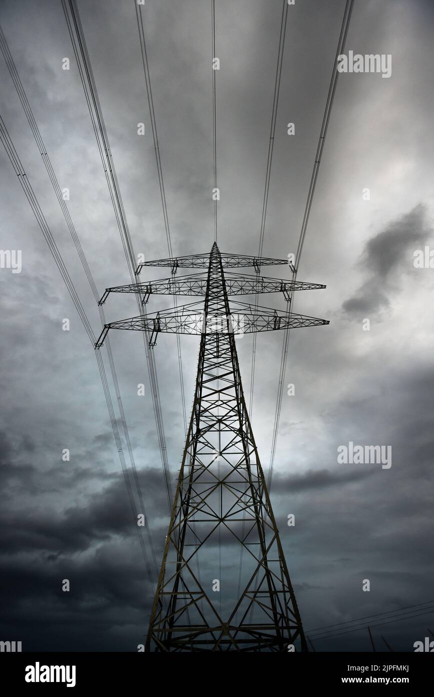 Norsingen, Germania. 18th ago, 2022. Un polo di potenza con le linee mancanti si trova contro un cielo nuvoloso in un campo. La guerra della Russia in Ucraina potrebbe causare strozzature nell'approvvigionamento energetico nel prossimo autunno e inverno. Credit: Philip von Ditfurth/dpa/Alamy Live News Foto Stock
