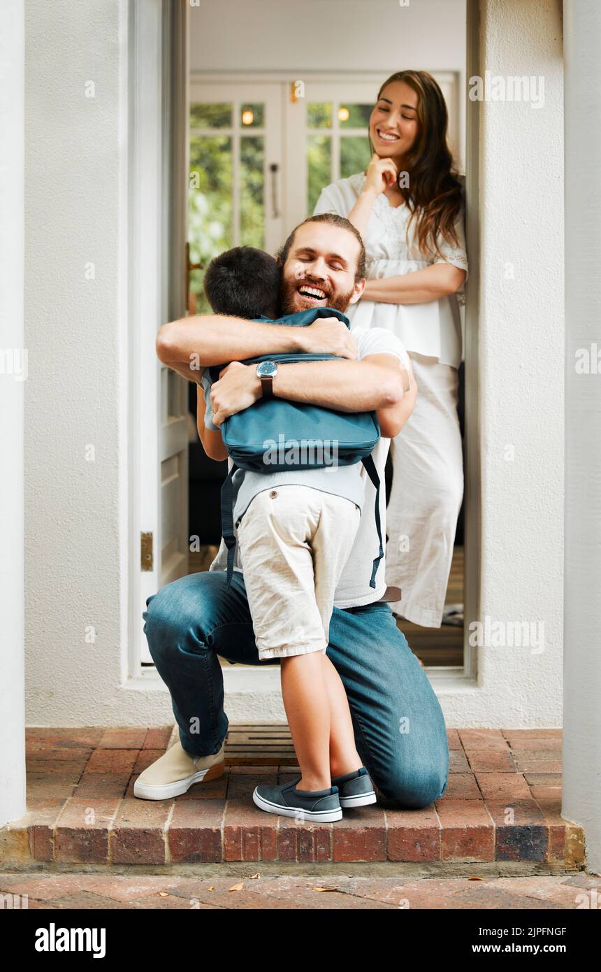 Amare il papà abbracciare e abbracciare il figlio, l'amore da padre a figlio o i genitori dicendo Arrivederci a bambino sul portico anteriore a casa. Felice famiglia saluto piccolo ragazzo Foto Stock