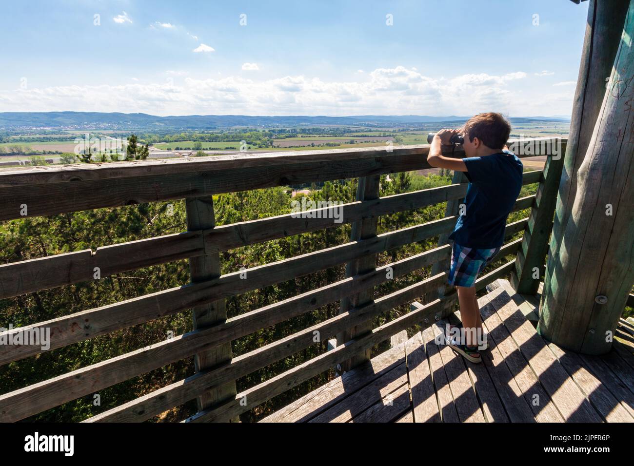 Bambino che guarda attraverso binocoli in cima alla torre panoramica Hubertus verso sud-ovest, Sopron, Ungheria Foto Stock