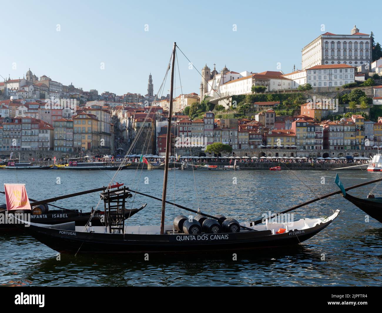 Barche tradizionali che trasportano botti di vino sul fiume Douro con la riva del fiume, l'area Ribeira di Porto alle spalle. Portogallo. Foto Stock