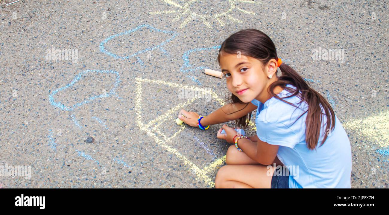 I bambini disegnano la casa della bandiera Ucraina sul marciapiede. Messa a fuoco selettiva. Foto Stock