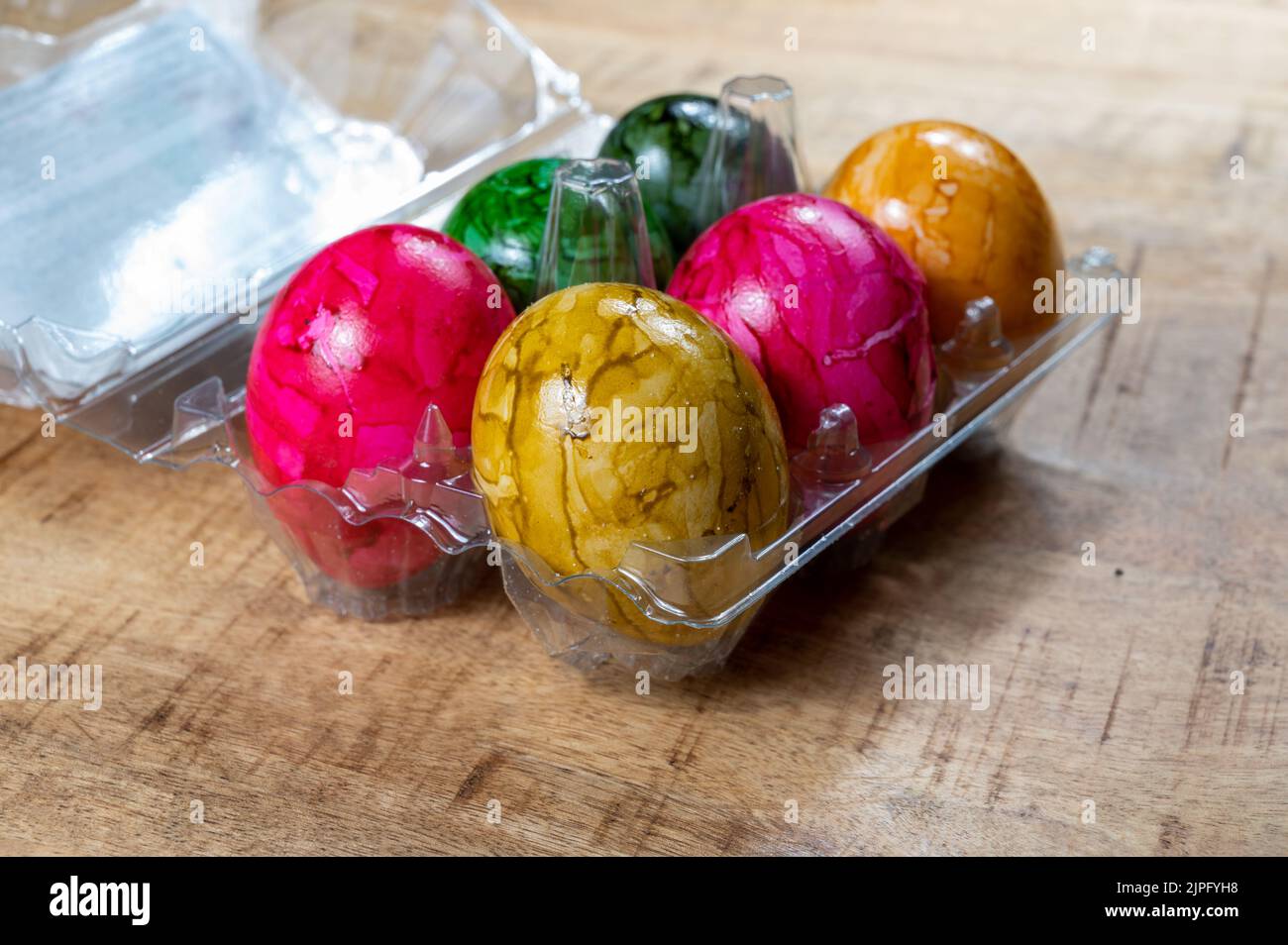 Colorate uova di Pasqua in scatola di plastica per la celebrazione della Pasqua cattolica in aprile, primo piano Foto Stock