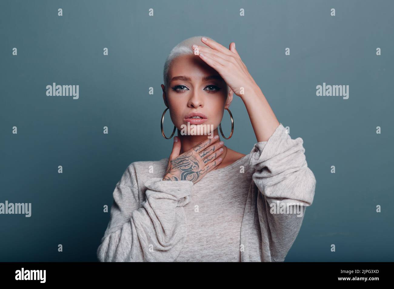 Giovane donna millenaria con corto ritratto dei capelli biondi facendo viso yoga auto massaggio viso per la pelle del viso Foto Stock