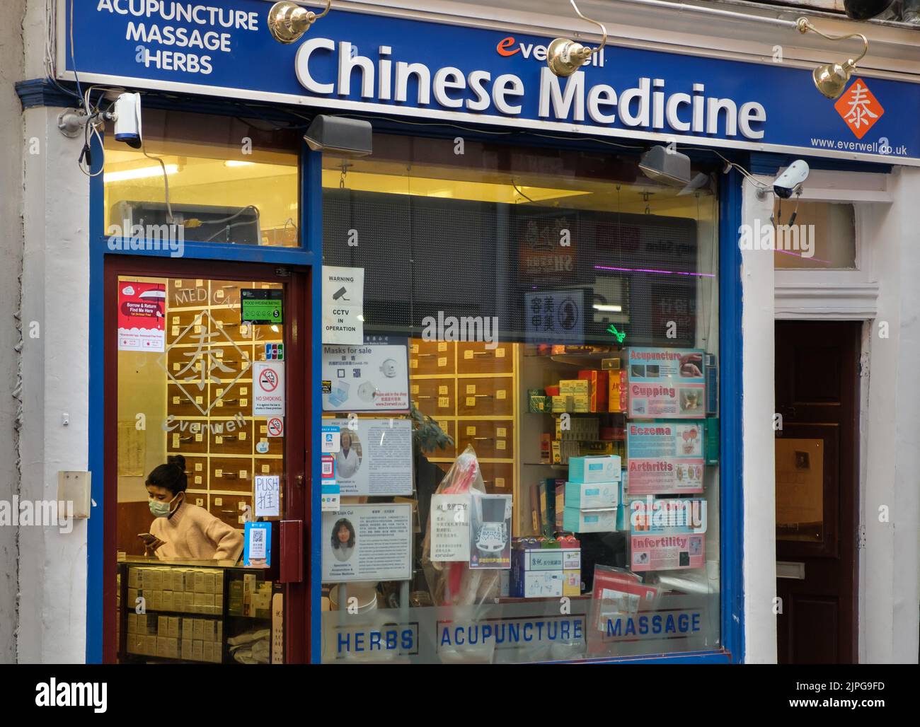 Durante l'epidemia di Coronavirus (Covid-19) persone con maschera di viso lavoro nel negozio di medicina cinese a Chinatown Foto Stock