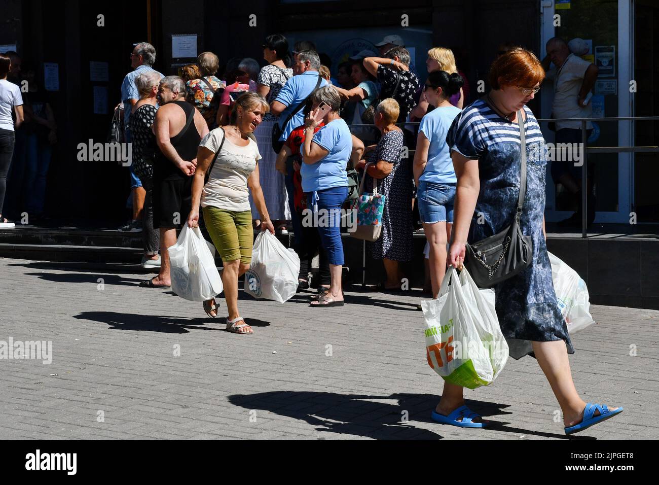 Zaporizhzhzhia, Ucraina. 8th ago, 2022. Le persone ricevono aiuti alimentari in un punto di distribuzione degli aiuti umanitari a Zaporizhzhia. Dall'inizio dell'invasione russa, quasi un terzo degli ucraini è stato costretto a lasciare le loro case. Secondo l’Agenzia delle Nazioni Unite per i rifugiati, questa è una delle più grandi crisi di sfollamento umano al mondo. Le persone che si trovano nelle aree direttamente colpite dal conflitto hanno bisogno immediato di un sostegno salvavita, mancano cibo, energia, servizi pubblici e si trovano di fronte a un fallimento nella fornitura di servizi di base. Essi si trovano inoltre ad affrontare il rischio di disastri ambientali a causa della vicinanza ad h Foto Stock