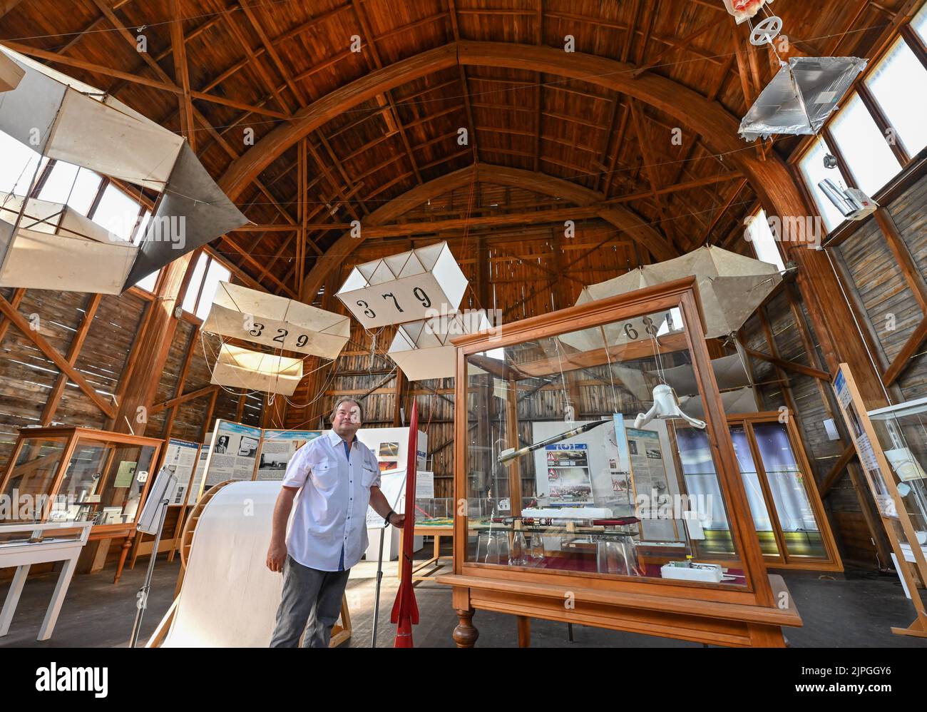 18 agosto 2022, Brandeburgo, Lindenberg: Bernd Stiller, presidente del Museo del tempo, si trova nella storica sala mongolfiera dal 1936 con gli aquiloni meteorologici sul soffitto. Lo stesso giorno, il Ministro della Cultura Schüle del Brandeburgo (SPD) ha visitato il Museo del tempo per consegnare notifiche di sovvenzione di circa 53.000 euro come parte del programma per promuovere la trasformazione digitale delle istituzioni culturali nello stato di Brandeburgo (DIWA). Il Museo del tempo (Museo di Meteorologia e di Aerologia) è stato fondato nel 2006. Fornisce informazioni sui fenomeni meteorologici e mostra come viene misurato il tempo - f Foto Stock