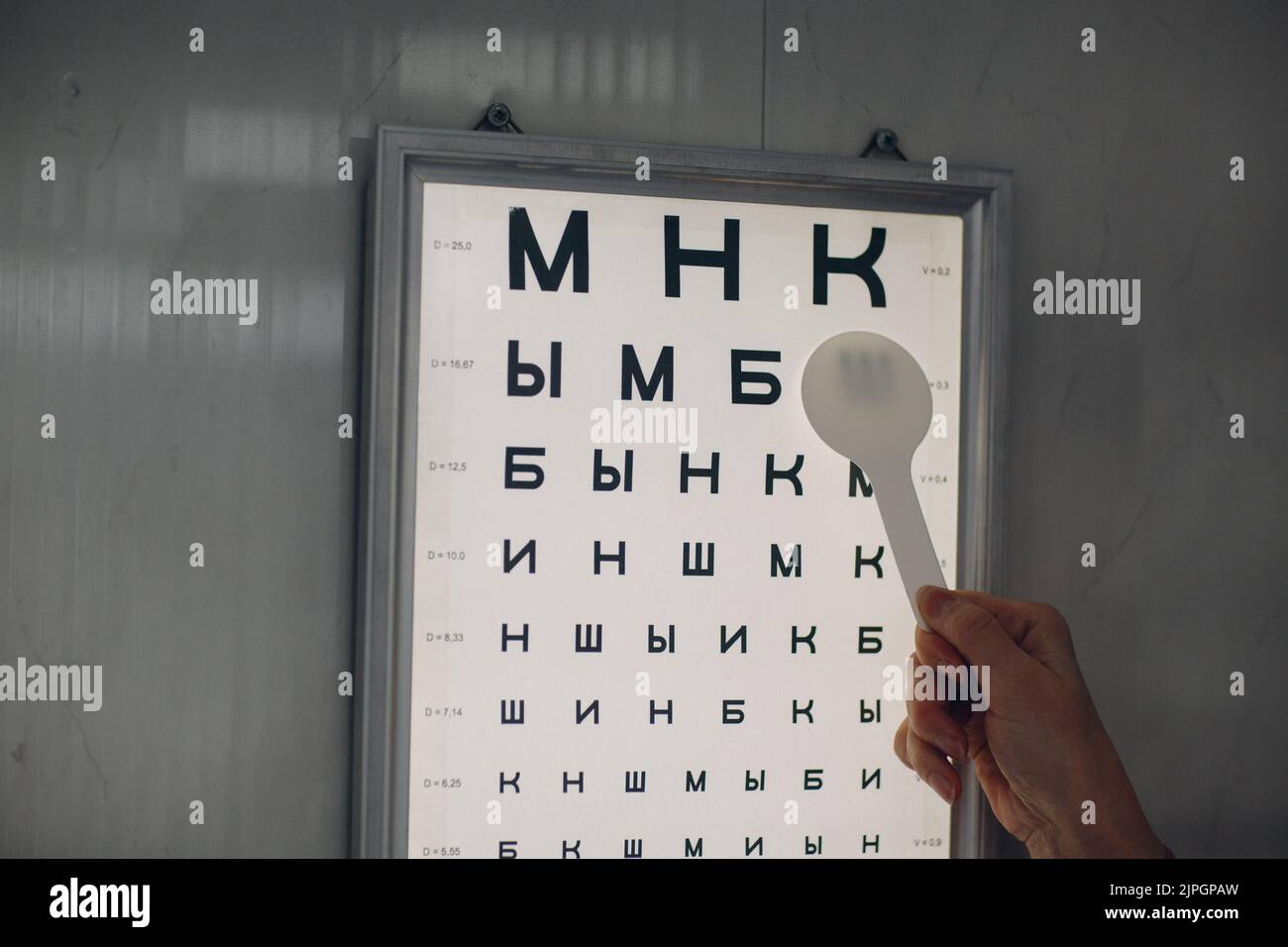 Medico ottico con grafico a lettere per il controllo del test di visione oculare. Foto Stock