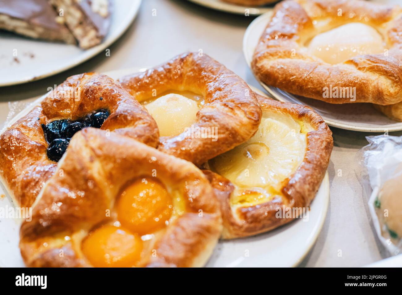 Una selezione di dolci danesi su un piatto Foto Stock