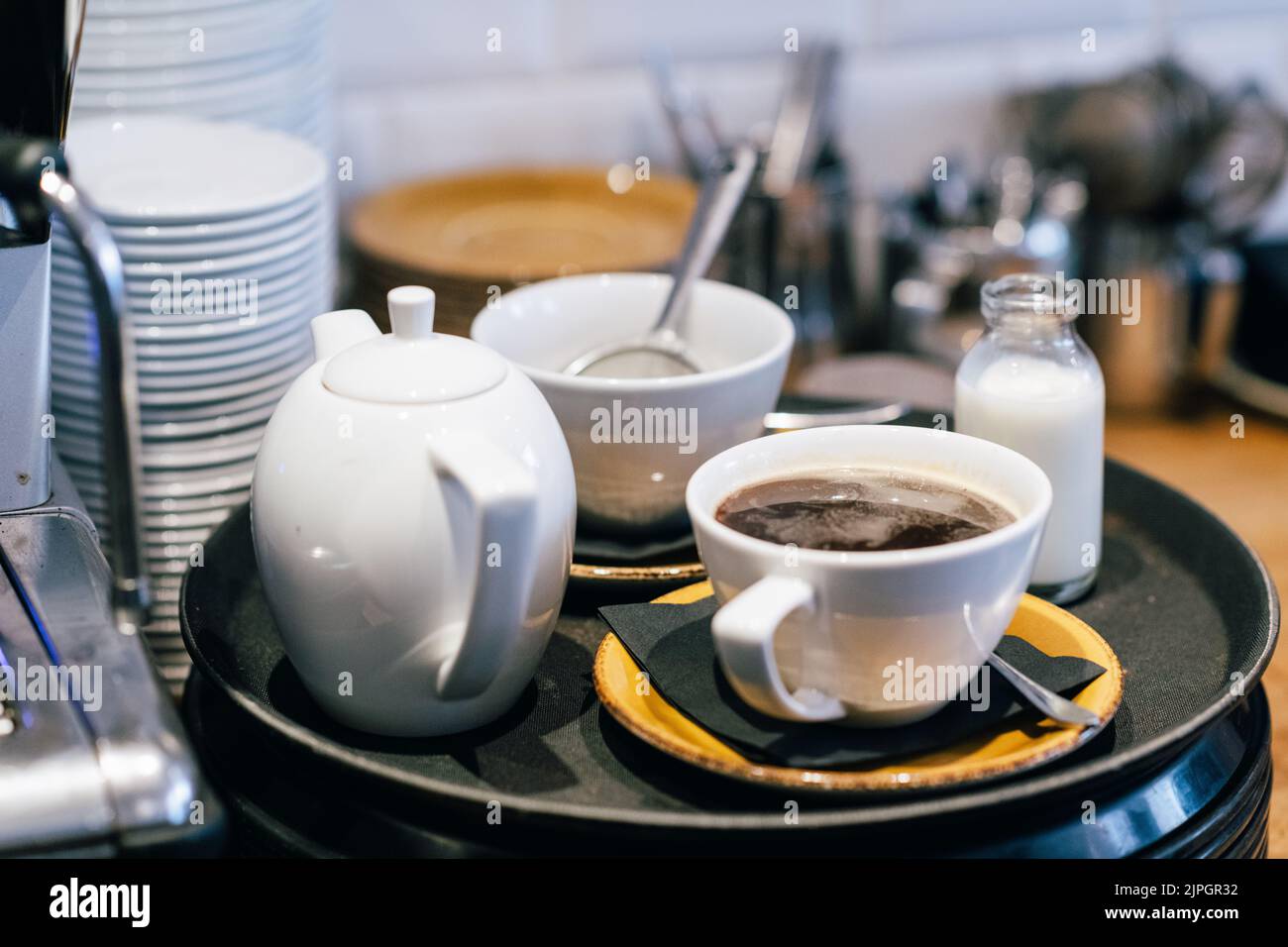 Un vassoio con caffè nero e latte in un bar ristorante Foto Stock