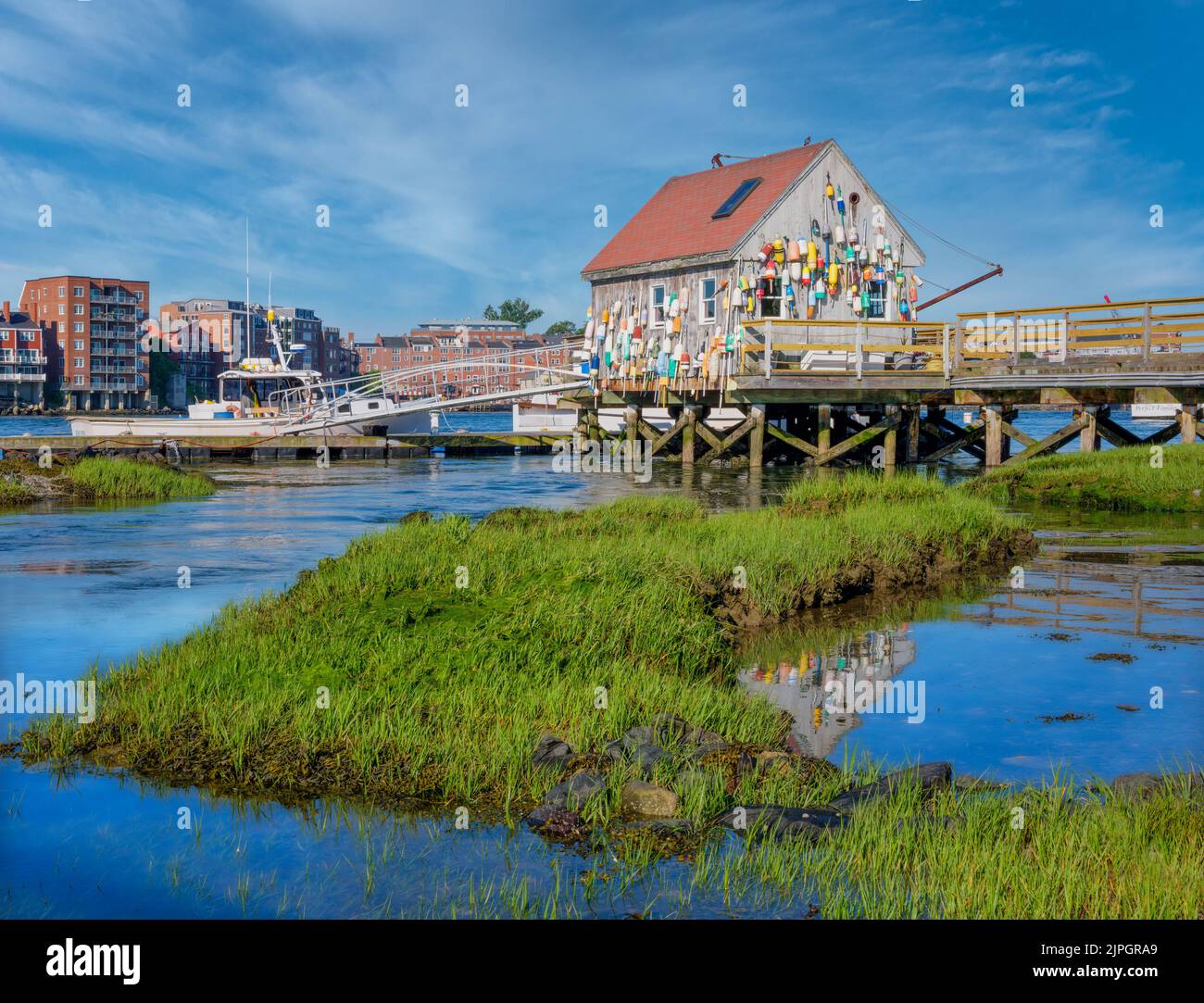 Una vecchia aragosta dal tetto rosso decotata con molti galleggianti e altre paraphernalia di pesca. Foto Stock