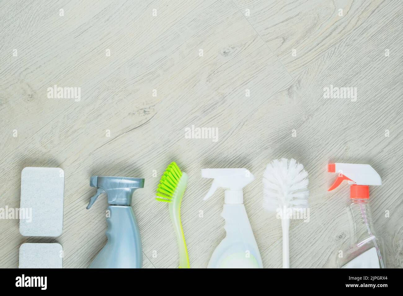 Detergenti spray. Сleaning accessori. Impilare le spugne e il flacone di pulizia con un detergente su fondo in legno. Concetto di servizio. Foto Stock
