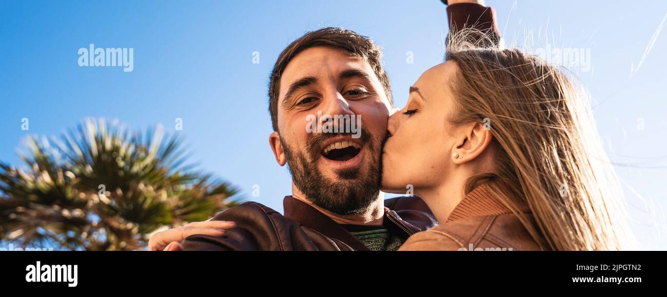 Banner orizzontale o intestazione con giovane coppia hippster che si diverte a scattare un ritratto selfie contro un bellissimo panorama al tramonto. Fidanzata e fidanzata Foto Stock