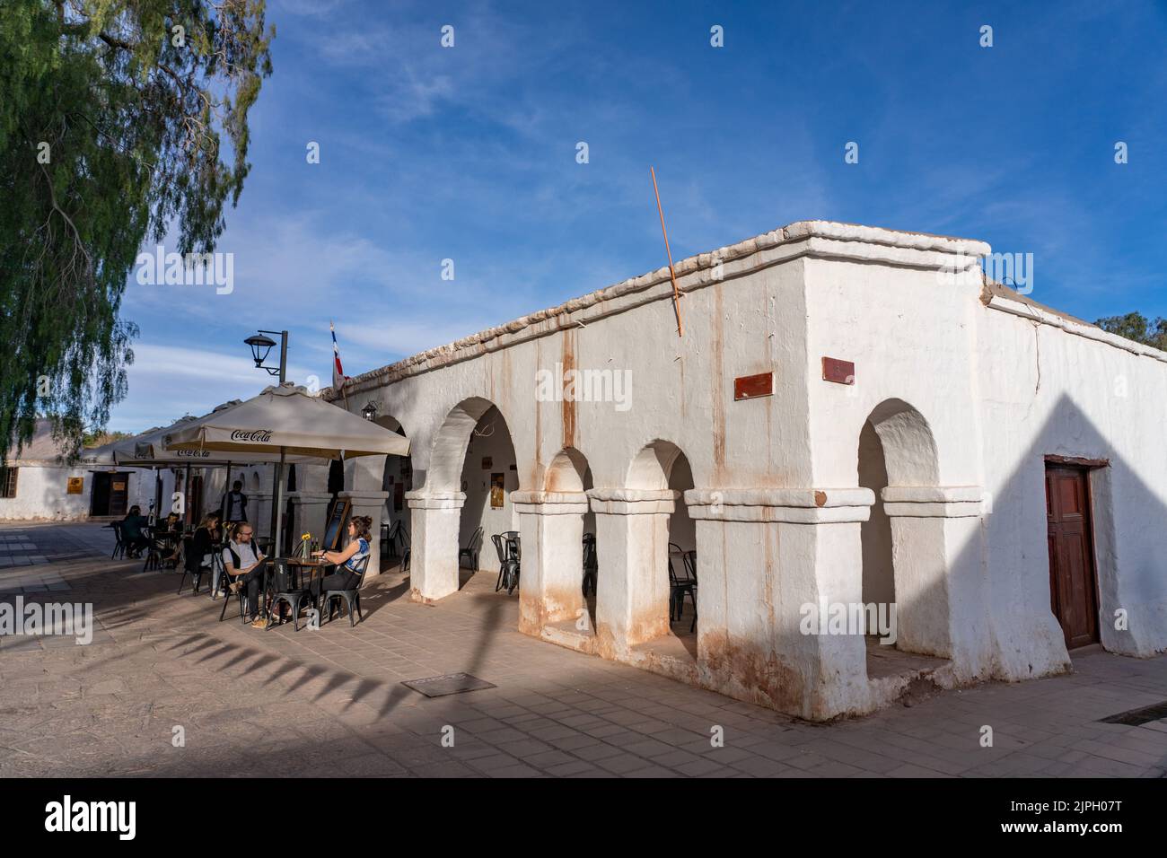 I turisti possono gustare un pasto all'aperto intorno alla piazza principale nella città di San Pedro de Atacama, nel nord del Cile. Foto Stock