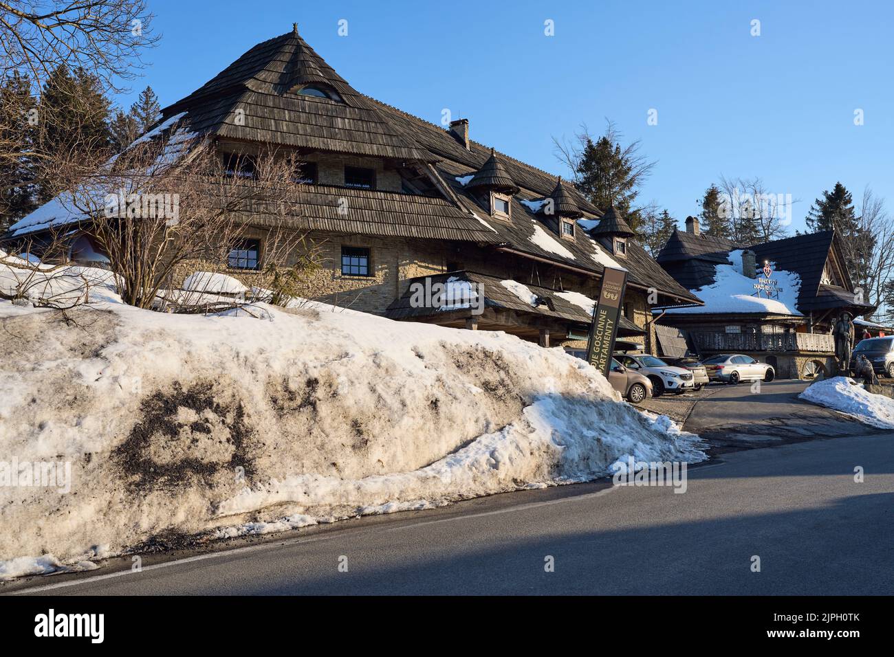 SZCZYRK, POLONIA il 2022 marzo: Tradizionale locanda in legno nelle Montagne di Beskid Slesiane su bialy Krzyz europeo, cielo blu chiaro in fredda giornata di sole inverno. Foto Stock